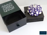 a small purple and white object in a black box