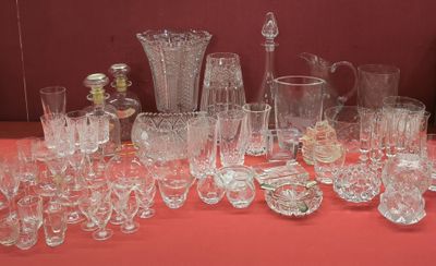 de nombreux verres et vases posés sur une table avec un fond rouge