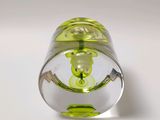a small glass object with a green design on it