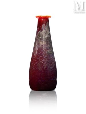 un vase rouge posé sur une surface blanche