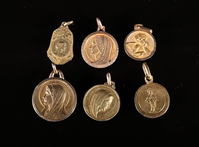 quatre médailles d'or sur lesquelles figurent une femme et un homme