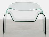 a clear glass coffee table with curved legs and a curved glass top