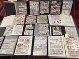 beaucoup de timbres posés sur une table, avec de nombreux classeurs