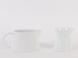 pair of white ceramic pitchers on a white background
