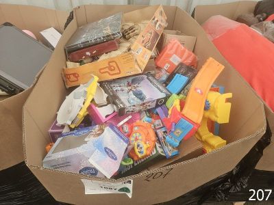 une boîte en carton remplie de jouets divers posée sur un canapé