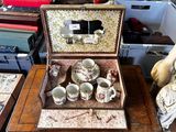 une petite boîte en bois contenant des tasses à thé, posée sur une table