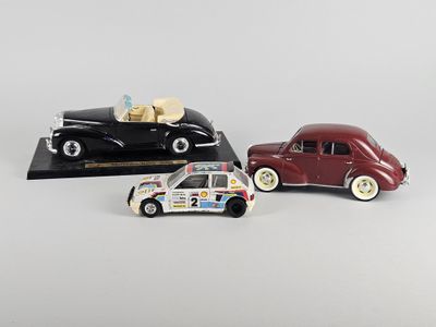 Deux petites voitures sont posées l'une à côté de l'autre sur une surface blanche.
