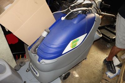 un homme qui se tient à côté d'une machine bleue