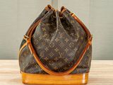 a louis vuitton bucket bag sitting on a wooden table