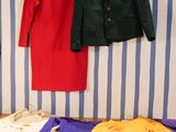 un lit avec des vêtements accrochés au mur à côté