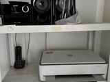 a white shelf with a printer and other electronics on it