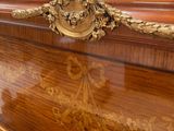 a wooden dresser with a gold decoration on the top