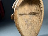 a person holding a piece of wood with a face on it