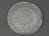 a close up of a silver coin with a wreath on it