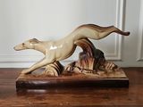 a figurine of a dog running on a wooden table
