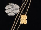 three different necklaces and a coin on a black surface