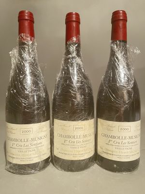 three bottles of wine wrapped in plastic sitting on a counter