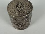 an antique silver box with a floral design on the lid