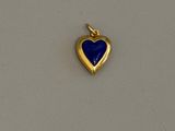 une photo d'un pendentif en or en forme de cœur, orné d'une pierre de lapis-lazuli au centre