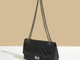 un sac à main noir matelassé muni d'une bandoulière en chaîne
