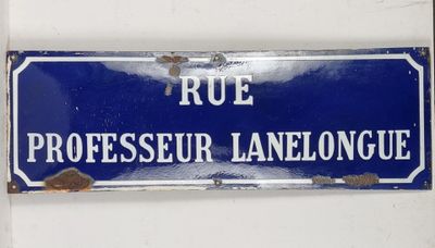 blue and white street sign on a white wall in a french language