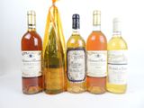 plusieurs bouteilles de vin sont alignées sur une surface blanche