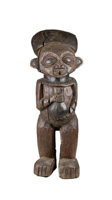 une vieille statue en bois d'un homme avec un chapeau sur la tête
