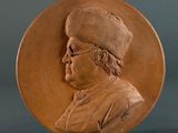 a brown medallion with a picture of a man on it