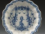 une assiette bleue et blanche ornée de motifs représentant des personnages