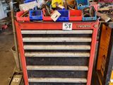 une boîte à outils rouge sur laquelle sont posés des outils, dans un garage