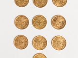 several gold coins are arranged in a triangle on a white surface