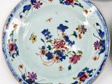 two plates with flowers on them sitting on a table