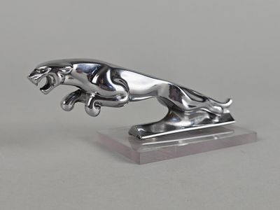 une figurine en argent représentant un lion, posée sur un socle