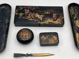 a black and gold box with a pen, scissors, and other items