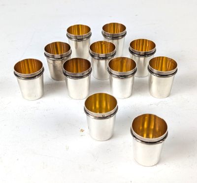 des verres à shot argentés et dorés posés sur un fond blanc
