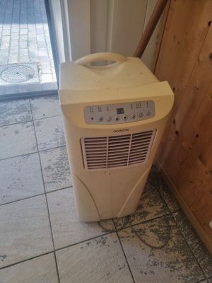 a small air conditioner sitting in the corner of a room