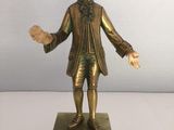 statue d'un homme en costume-cravate, debout sur un socle