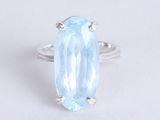 a close up of a blue topaz ring on a white surface