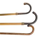two old fashioned wooden and metal walking canes on a white background