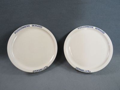 deux assiettes blanches avec des inscriptions bleues, posées sur une table