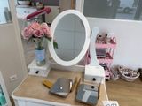 a white dresser with a mirror and a phone on it
