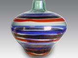 un vase en verre orné d'un motif à rayures multicolores