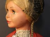 a doll that is wearing a red shirt and a hat