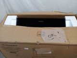 une boîte en carton contenant un ordinateur portable, posée par terre