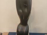 a black sculpture on a table with a pair of scissors on it