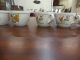 four coffee cups sitting on a table in a room