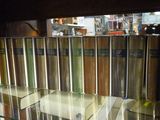 une étagère en verre sur laquelle sont posés tout un tas de livres