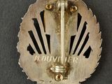 an image of a metal badge with a crown on it