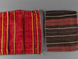 two pieces of red and black striped cloth on a gray surface