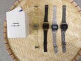 three watches and a watch box on a table